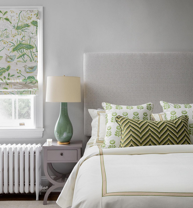 Мінімалістична спальня з лаконічним ліжком з м'якою спинкою без деталей.