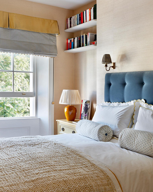 Затишна спальня з високою м'якою спинкою ліжка для комфорту та підтримки.