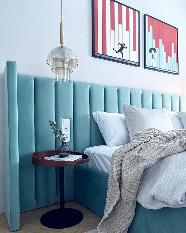 Стильна спальня з ліжком з м'якою спинкою нейтрального кольору для комфорту.