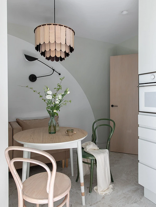 Скляний стіл: стиль Елегантний скляний круглий стіл з білими стільцями в сучасній мінімалістичній кухні.