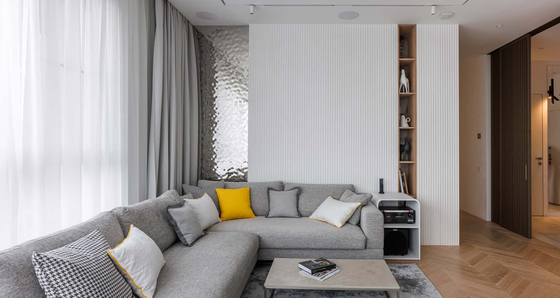 Сучасний дизайн вітальні з використанням фрезерованих панелей в оздобленні стін.