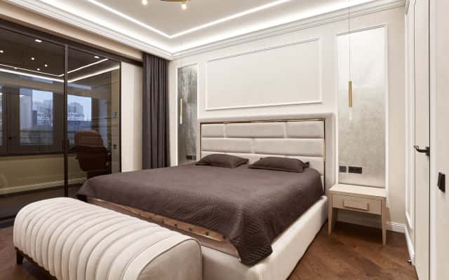 Сучасна спальня після ремонту з дерев'яними елементами та м'яким килимом.