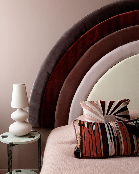 Узголів'я з ротангу Затишна спальня з ліжком з плетеним узголів'ям з ротангу та рослинами.