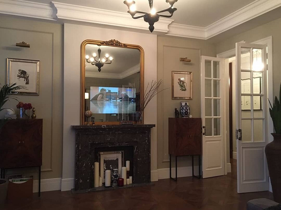 Мінімалістична ніша для телевізора в білому кольорі з декоративними елементами.