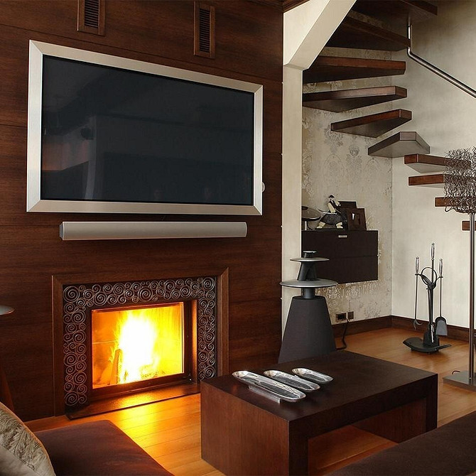 Простора вітальня з великим телевізором, вбудованим в нішу з гіпсокартону.