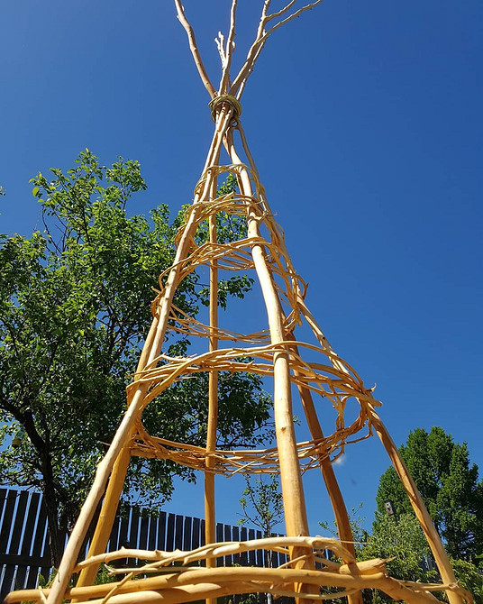 Саморобна опора для клематисів з підручних матеріалів у квітучому саду.