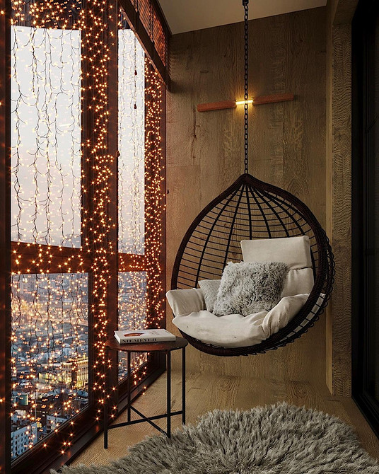 Підвісне крісло-кокон у вітальні, зручне місце для відпочинку та релаксу.