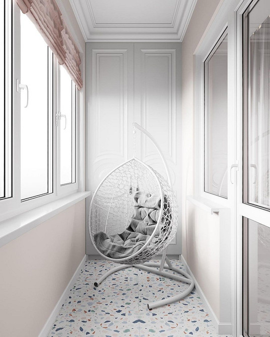 Підвісне крісло з ротангу на терасі, стильний елемент дизайну зони відпочинку.