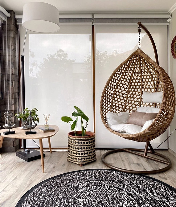 Плетене підвісне крісло гамак на терасі: затишна зона відпочинку на свіжому повітрі.