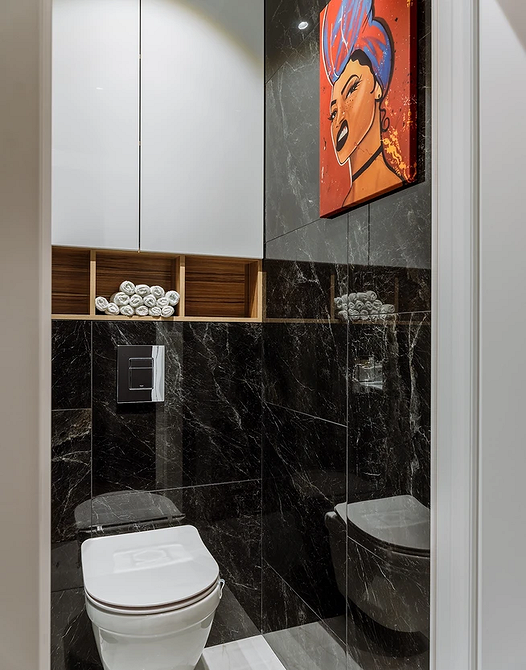 Книжкові полиці від підлоги до стелі в дизайні сучасної домашньої бібліотеки.