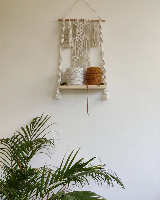 Сучасний інтер'єр з настінними полицями для книг, декору та рослин.