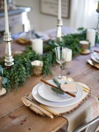 Різдвяний хвойний декор: святковий букет з ялинкових гілок, прикрашений іграшками на столі.