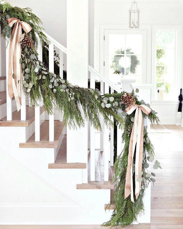 Різдвяні прикраси з хвої: гірлянда з ялинкових гілок прикрашає вхідні двері.