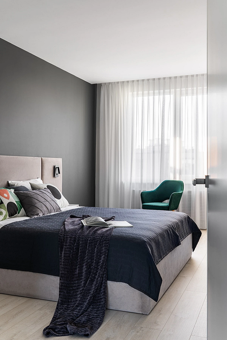 Сірий Комфорт Затишна спальня в сірих тонах з м'яким ліжком та дерев'яними елементами.