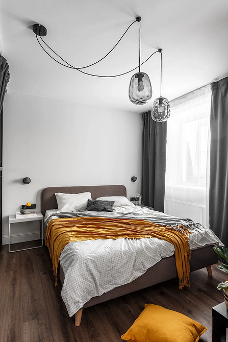 Декор та Ліжко Затишна спальня з сірим ліжком, прикрашена картинами та декоративними елементами.