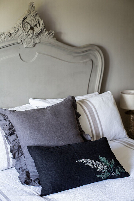 Елегантне сіре ліжко з металевим каркасом у мінімалістичній спальні.