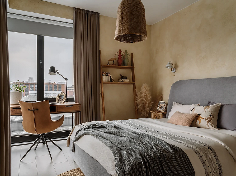 Світла Гармонія Інтер'єр спальні з сірим ліжком та постільною білизною у світлих тонах.