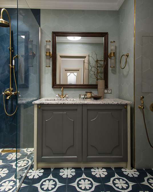 Сіра тумба та дзеркало Сучасний інтер'єр ванної кімнати: сіра тумба під раковину, велике дзеркало та мінімалістичний декор.