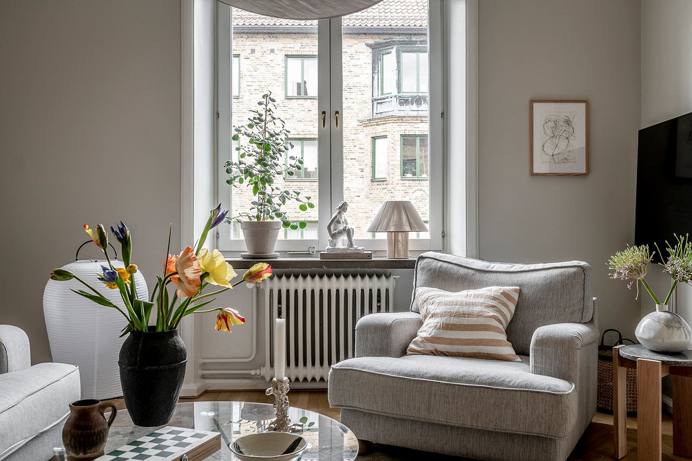 Елегантний дизайн 2026: сіра м'яка мебель в інтер'єрі вітальні з великими вікнами.