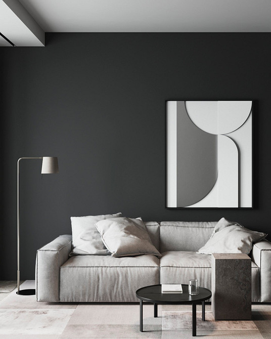 Сірий шкіряний диван в інтер'єрі з книжковими полицями та робочим місцем