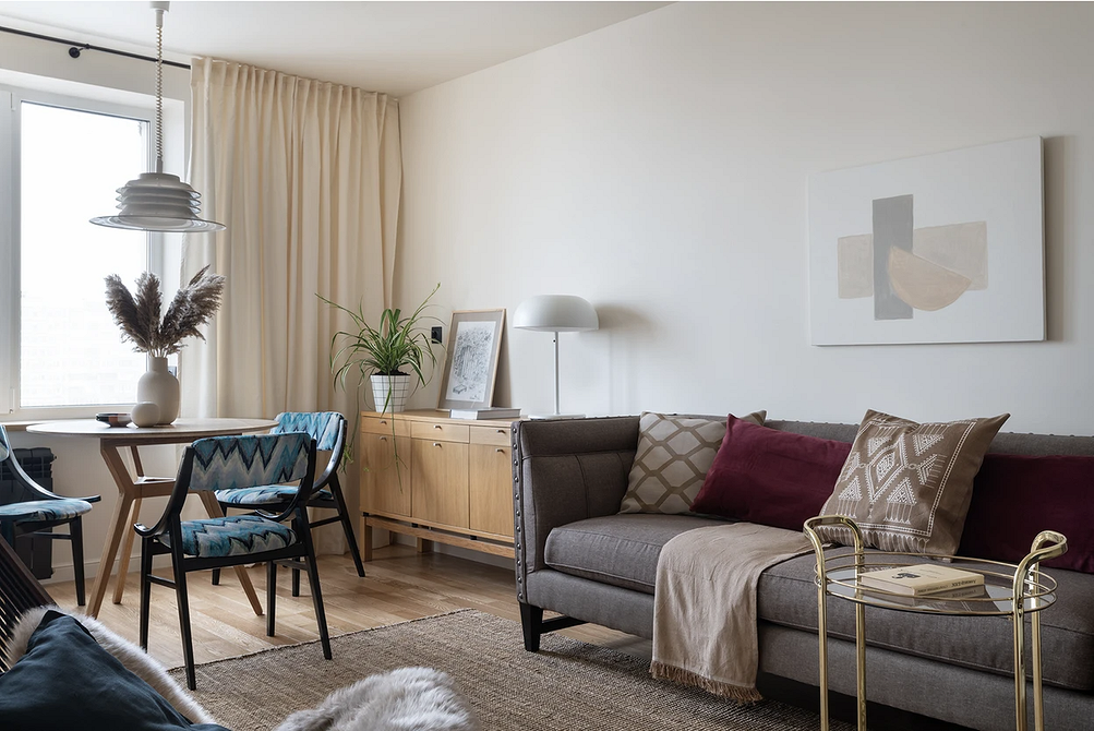 Вишуканий текстиль для сірого дивана: подушки, пледи, килим, створюють гармонійний ансамбль.