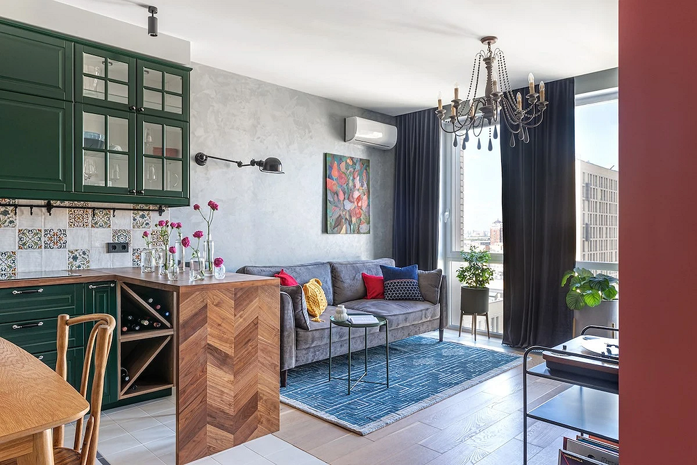 Інтер'єр вітальні з сірим модульним диваном, рослинами та дерев'яними елементами декору.