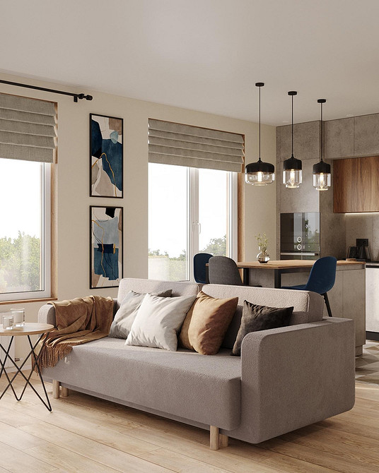 Комфортний сірий диван з великою кількістю подушок різних розмірів та кольорів.