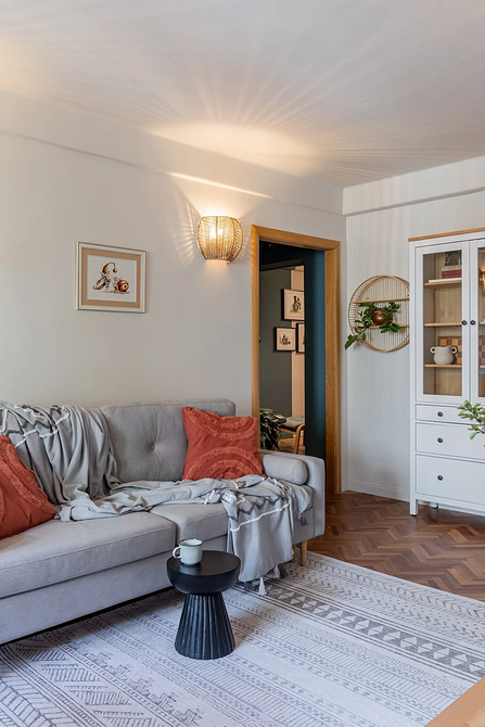 Сучасний сірий кутовий диван 2026 з подушками різних текстур у світлій вітальні.