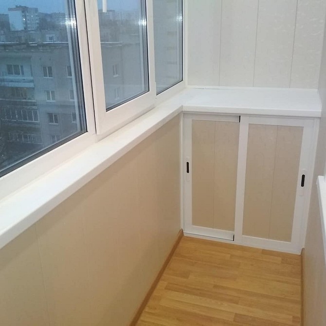 Сучасний дизайн шафи на балкон з білими фасадами та дерев'яними полицями