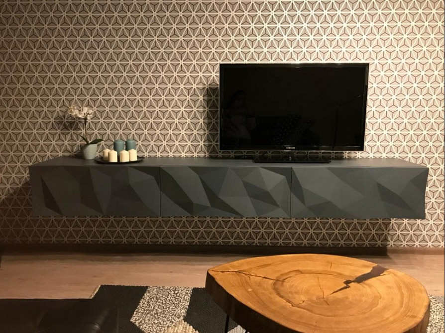 Мінімалістична тумба під телевізор з відкритими полицями для зберігання речей.