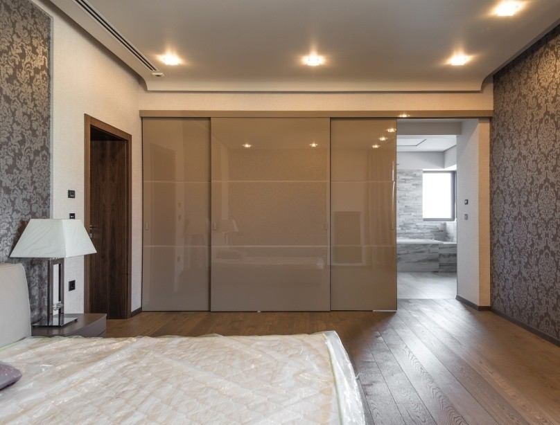 Шафа-купе з розсувними дверима з натурального дерева в еко-спальні.
