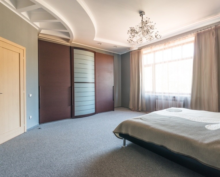 Чорна шафа-купе з глянцевими фасадами для сучасної чоловічої спальні.