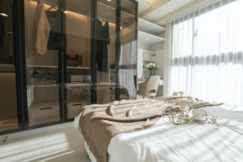 Містка шафа-купе з матовими скляними фасадами у мінімалістичній спальні.