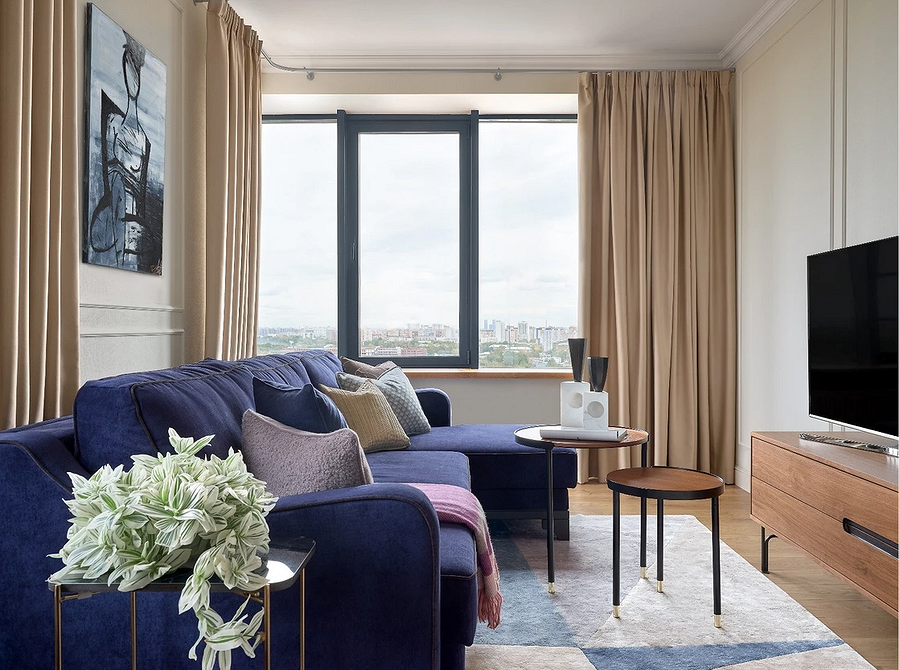 Синій диван: стиль 2026 Тенденції інтер'єру 2026: стильний синій диван у світлій вітальні з бежевими стінами.