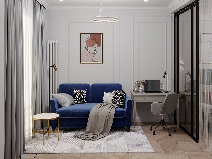 Стильний синій велюровий диван у вітальні з килимом та рослинами.