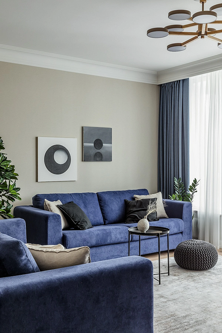 Сучасний інтер'єр з синім диваном, дерев'яним столиком та зеленими рослинами, дизайн меблів.