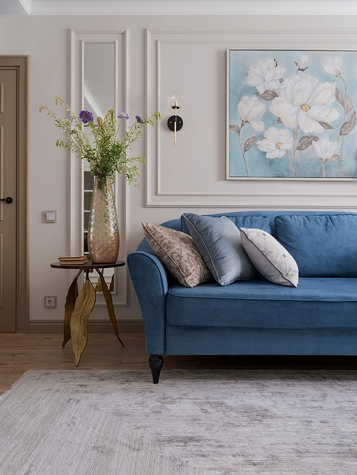 Синій велюровий диван з декоративними подушками різних кольорів, текстиль в інтер'єрі.