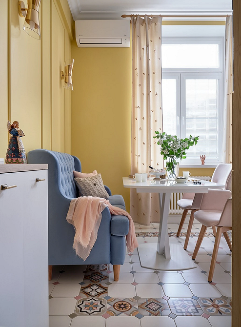 Дизайн вітальні з синім диваном: декоративні подушки та килим у гармонійному поєднанні.