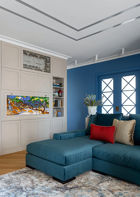 Книжкові полиці та диван Синій диван в інтер'єрі з книжковими полицями: затишна вітальня для читання