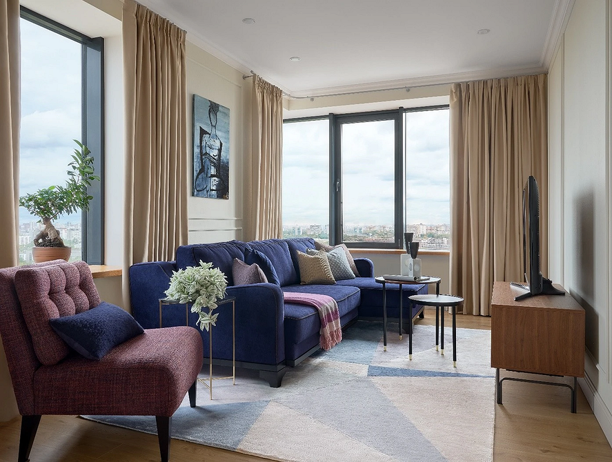 Бежевий та синій: ідеально! Поєднання кольорів в інтер'єрі 2026: синій диван, бежеві стіни, світла вітальня.