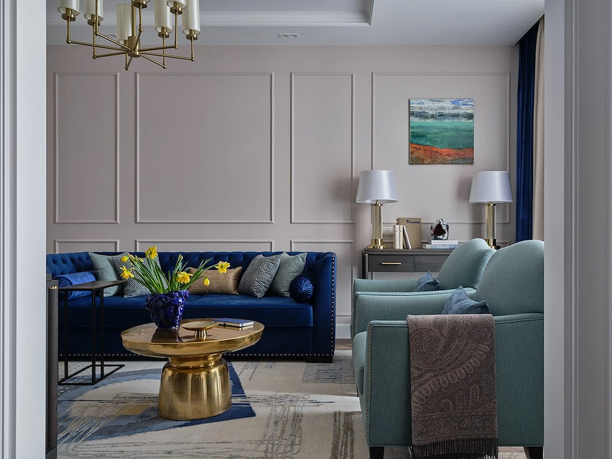 Сучасний дизайн інтер'єру з синім диваном та яскравими акцентами в текстилі.