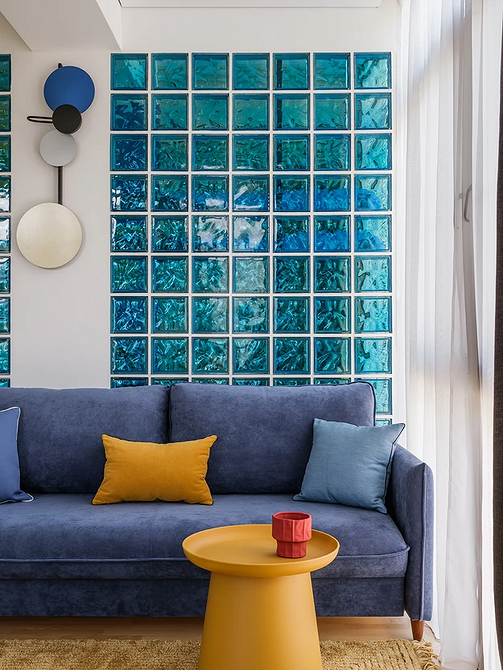 Синій диван в поєднанні з бежевими стінами та дерев'яною підлогою, меблі для дому.