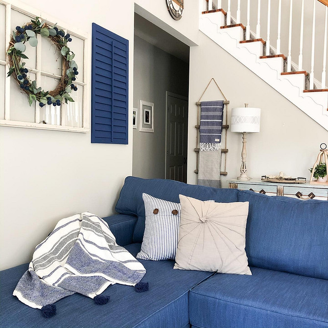Елегантний синій диван Синій диван в інтер'єрі: бежеві стіни, камін, елегантний стиль вітальні