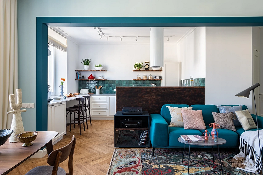 Синій диван в інтер'єрі з дерев'яною підлогою та килимом