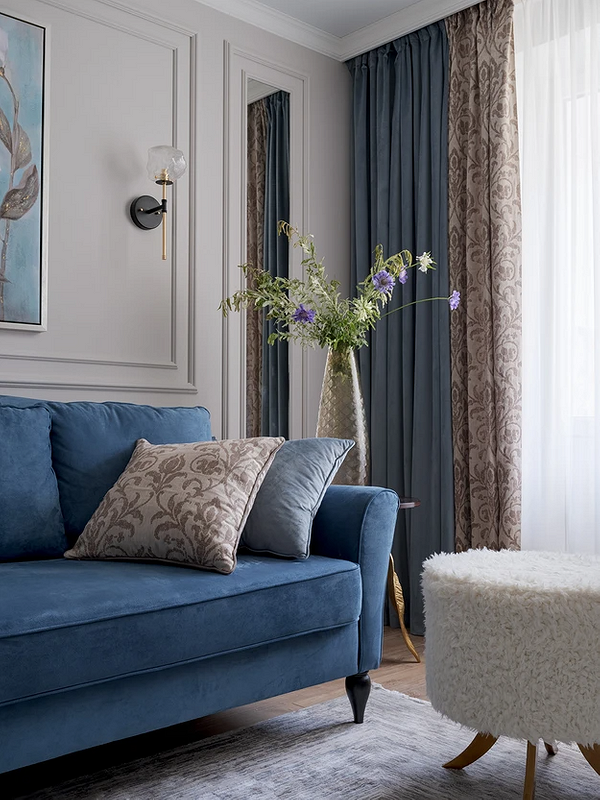 Синій диван в інтер'єрі вітальні з декоративними подушками та килимом, меблі для дому.