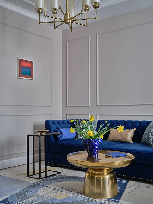 Скандинавський стиль: синій диван, білі стіни, мінімалістичний декор, текстиль в інтер'єрі.