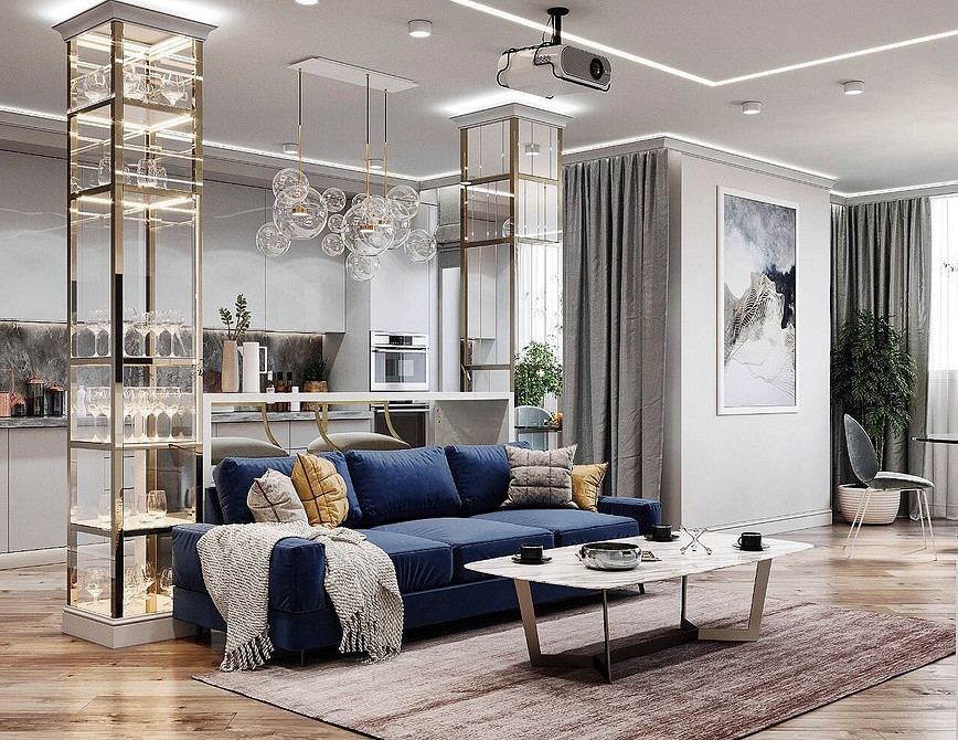 Яскрава вітальня з синім диваном, жовтим кріслом та зеленими рослинами.