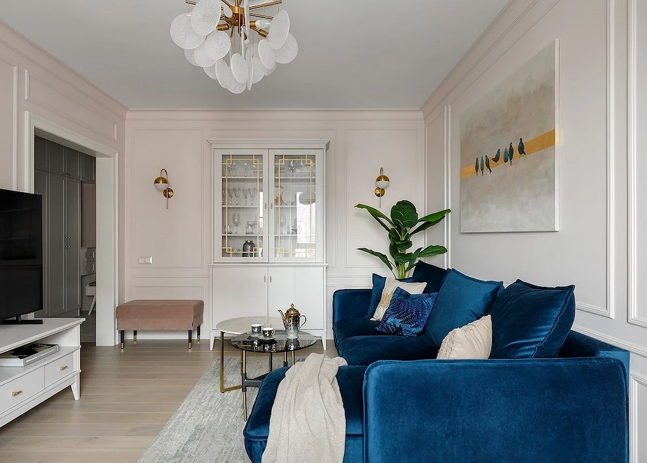 Сучасна вітальня з синім диваном, абстрактним мистецтвом на стінах та килимом