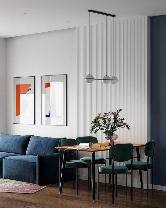 Синій кутовий диван у світлій вітальні з дерев'яною підлогою та килимом