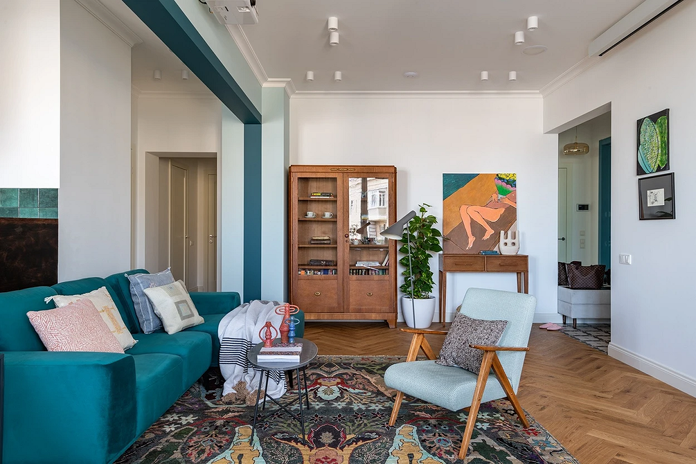 Синій диван з різнокольоровими подушками в сучасному інтер'єрі